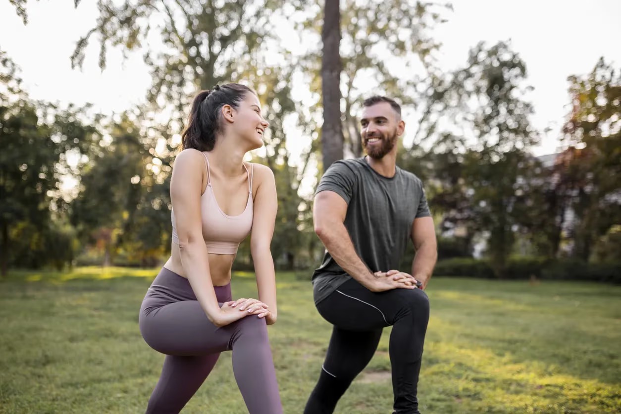 Two people stretching in a field together