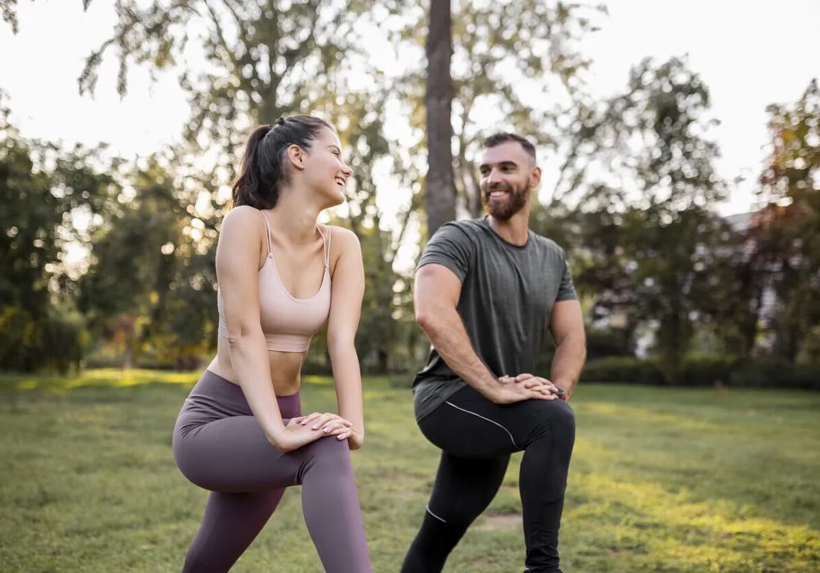 Two people stretching in a field together